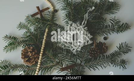 Makramé Schneeflocke Weihnachten Feiertagsdekoration auf Ästen mit Makrame handgefertigten Knot-Technik Stockfoto