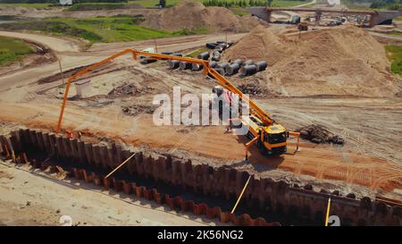 LKW-Kran und ein LKW-Betonmischer. Offene Grabenaushub und unterirdischer Bau von Versorgungsunternehmen in Warschau, Polen. Luftaufnahme. Hochwertige Fotos Stockfoto