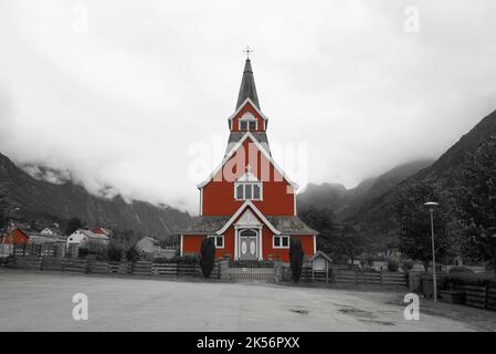 Alte 'Neue Kirche', erbaut 1934, Olden, Norwegen. Norwegen rote Kirche. Holzkirche. Umgeben von Bergen und niedrigen Wolken. Schwarzweißbearbeitung. Stockfoto