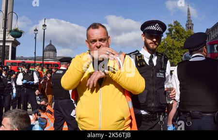 London, England, Großbritannien. 6. Oktober 2022. Ein Polizeibeamter verhaftete einen Protestierenden von Just Stop Oil, der die Straßen auf dem Trafalgar Square blockierte. Einige Aktivisten klebten ihre Hände an die Straße, während andere sich an Metallrohren befestigten, und der Protest war Teil einer Reihe von Demonstrationen, die täglich in Westminster stattfanden, wobei die Klimaschutzgruppe ein Ende der fossilen Brennstoffe und einen Wechsel zu erneuerbaren Energien forderte. (Bild: © Vuk Valcic/ZUMA Press Wire) Stockfoto