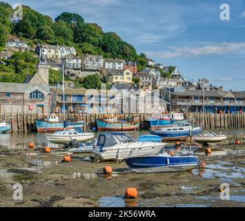 Ein Blick über den Hafen von Looe mit Blick von Westen nach Osten auf die Mündung, wenn an einem Sommertag die Flut ist, und vor Anker liegen Freizeitboote und Fischerboote. Stockfoto