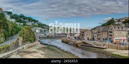 Eine Weitwinkelaufnahme mit Niedrigwasser, das zwischen West- und East Looe, Cornwall, läuft. Wohn- und Ferienimmobilien säumen die wunderschöne Mündung. Stockfoto