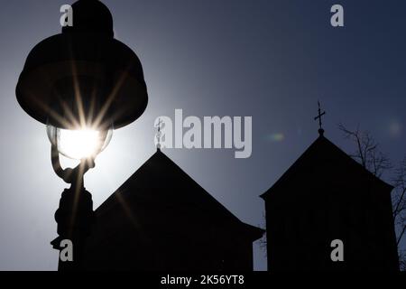 06. Oktober 2022, Niedersachsen, Osnabrück: Hinter den Türmen des Osnabrücker Doms ist die untergehende Sonne zu sehen. Foto: Friso Gentsch/dpa Stockfoto