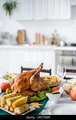 thanksgiving Dinner mit traditionellem gebratenem truthahn und gegrilltem Mais in verschwommener Küche, Stockbild Stockfoto