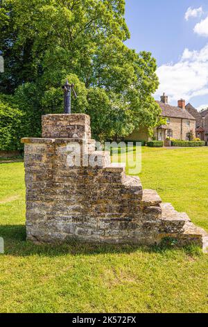 Eine gusseiserne Wasserpumpe auf einem hohen Steinblock auf dem Grün im Cotswold-Dorf Meysey Hampton, Gloucestershire, England, Großbritannien Stockfoto