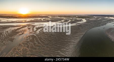 Frankreich, Somme, Somme Bay, Le Hourdel, Sonnenaufgang über der Somme Bay und Sandbänke bei Ebbe mit Le Crotoy im Hintergrund (Luftaufnahme) Stockfoto