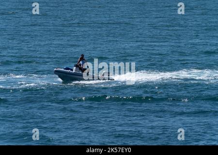 County Cork, Irland, 28. Mai 2022. Zwei Männer in einem Motorboot segeln an einem sonnigen Tag auf blauem Meer. Stockfoto