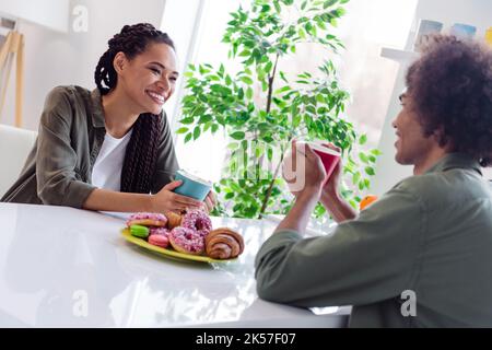 Foto von Happy Good Mood Geschwister verbringen Zeit zusammen in der Küche mit heißer Schokolade und unterhalten sich über alles Stockfoto