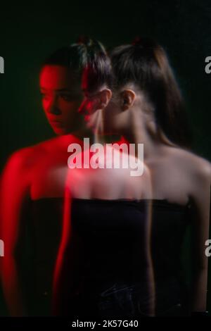 Weibliche Angst. Unbewusste Angst. Psychische Störung. Doppelbelichtung verwischen Silhouette Nachtportrait der gestörten Frau in rotem Neonlicht isoliert auf da Stockfoto