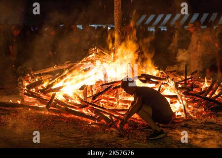 Frankreich, Eure, La Haye-de-Routot, traditionelles Lagerfeuer von Saint-Clair, eine 15 Meter hohe Pyramide aus trockenem Holz, wird auf dem Dorfplatz vor der Kirche und ihren tausendjährigen Eibungen errichtet. Eine Messe und ein Segen gehen der Verbrennung des Pfahls voraus, wenn das Kreuz an der Spitze nicht brennt, ist es ein gutes Zeichen für die kommenden 12 Monate, wenn ein verkohltes Holz, genannt brandon, nach Hause gebracht wird, wird das Haus vor Blitzschlag schützen Stockfoto