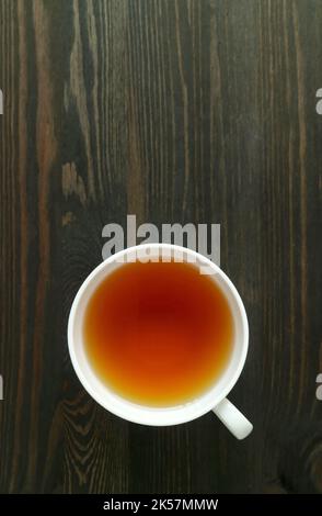Eine Tasse japanischer gerösteter Gerstentee oder Mugicha isoliert auf einem dunkelbraunen Holztisch Stockfoto