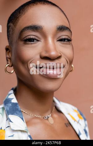 Porträt von glücklichen kurzhaarigen afroamerikanischen Frau Blick auf Kamera im Freien, Stock Bild Stockfoto