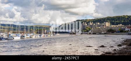Conwy, Großbritannien, September 28. 2022: Das Schloss von Edward I wacht über dem Fluss Conwy, der ein beliebter Anlegeplatz für kleine Boote und Yachten ist. Stockfoto