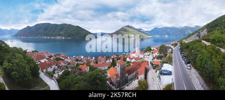 Luftaufnahme der historischen Stadt Perast an der Bucht von Kotor. Blick über die Dächer auf den campanile der Kirche St. Nikolaus und die Inseln St. George an Stockfoto