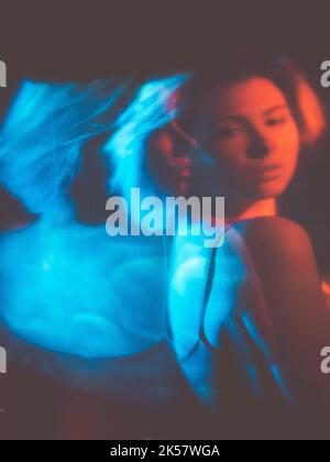 Angstanfall gestört Frau in rot-blauem Licht Stockfoto