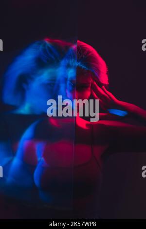 Psychische Störung gestört Frau in rosa blauem Licht Stockfoto