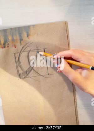 Zeichnung Künstler Hand Skizzieren auf rustikalem Papier Stockfoto