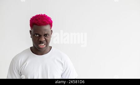 Schwarze Leben sind wichtig. Aggressiver Mann. Starke Leistung. Sozialer Druck. Hintergrund der Werbung. Wütender afrikanischer Kerl mit leuchtend rosa Haaren weißem T-Shirt isola Stockfoto