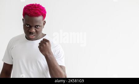 Brutaler Mann. Schwarze Leben sind wichtig. Geste bedrohen. Widerstrebige Gegner. Sozialer Druck. Hintergrund der Werbung. Aggressiver afrikanischer Kerl mit rosa Haaren Stockfoto