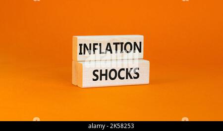 Symbol für Inflationsschocks. Konzept Worte Inflation Schocks auf Holzblöcke. Schöne orange Tisch orange Hintergrund. Die Inflation der Unternehmen erschüttert das Konzept. Stockfoto