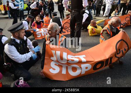 London, Großbritannien. 06. Oktober 2022. Während der Demonstration spricht ein Protestler mit einem Polizisten. Die KlimaaktivistInnen-Gruppe Just Stop Oil blockierte am 6.. Tag der Occupy Westminster-Aktion die Straßen rund um den Trafalgar Square und forderten, alle zukünftigen Lizenzen einzustellen und der Exploration, Entwicklung und Produktion fossiler Brennstoffe in Großbritannien zu zustimmen. Kredit: SOPA Images Limited/Alamy Live Nachrichten Stockfoto