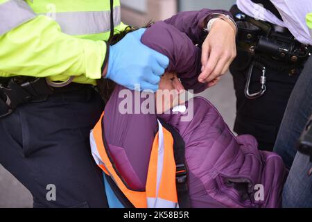 London, Großbritannien. 06. Oktober 2022. Ein Protestler wird während der Demonstration auf dem Trafalgar Square verhaftet. Die KlimaaktivistInnen-Gruppe Just Stop Oil blockierte am 6.. Tag der Occupy Westminster-Aktion die Straßen rund um den Trafalgar Square und forderten, alle zukünftigen Lizenzen einzustellen und der Exploration, Entwicklung und Produktion fossiler Brennstoffe in Großbritannien zu zustimmen. Kredit: SOPA Images Limited/Alamy Live Nachrichten Stockfoto