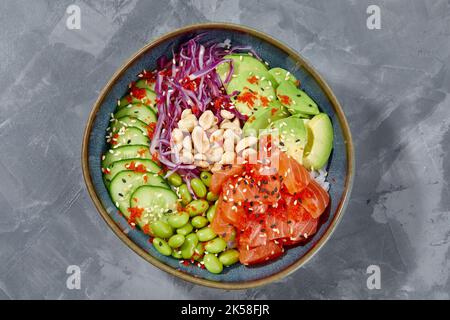 Draufsicht auf Sack-Salat mit Lachs und grünem Gemüse in den Schalen auf grauem Hintergrund. Speicherplatz kopieren. Stockfoto