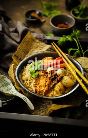 Laksa-Sauce. Peranakan Nudelsuppe mit Meeresfrüchten in würziger Kokosmilchsuppe aus Singapur Stockfoto