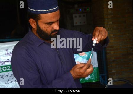 Peshawar, Khyber Pakhtunkhwa, Pakistan. 6. Oktober 2022. Ein Student erhält während einer Impfkampagne in Peshawar, an der Peshawar-Modellschule-Warsak-Straße, einen Typhus-Impfstoff. Nach Angaben des Gesundheitsministeriums werden alle Kinder im Alter zwischen 9 Monaten und 15 Jahren in der ersten Phase der Kampagne geimpft. (Bild: © Hussain Ali/Pacific Press via ZUMA Press Wire) Stockfoto