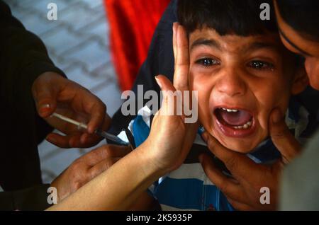 Peshawar, Khyber Pakhtunkhwa, Pakistan. 6. Oktober 2022. Ein Student erhält während einer Impfkampagne in Peshawar, an der Peshawar-Modellschule-Warsak-Straße, einen Typhus-Impfstoff. Nach Angaben des Gesundheitsministeriums werden alle Kinder im Alter zwischen 9 Monaten und 15 Jahren in der ersten Phase der Kampagne geimpft. (Bild: © Hussain Ali/Pacific Press via ZUMA Press Wire) Stockfoto