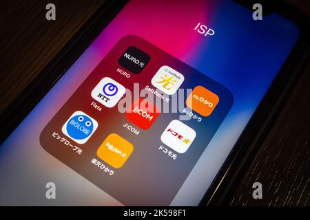 Japanische ISP-Symbole (Nuro Hikari, SoftBank Hikari, au Hikari, NTT Flets, J:COM, DOCOMO Hikari, Biglobe Hikari & Rakuten Hikari) auf dem iPhone in dunkler Stimmung Stockfoto