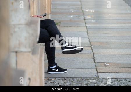 25.05.2021 - Handy-Nutzer sitzt vor einem Geschäft. 0CE210525D001CAROEX.JPG [MODEL RELEASE: NO, PROPERTY RELEASE: NO (c) caro images / Eckelt, ht Stockfoto