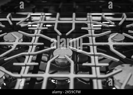 Küchenoberfläche aus Edelstahl mit gusseisernem Grill. Blick von oben. Herd Kochen Küche Herd Metall-Brenner Gas Küche Elektro-Heißkochfeld Stockfoto