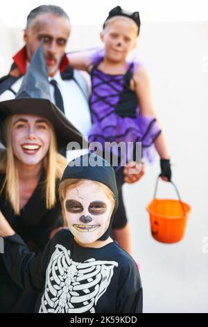 Überraschung. Eine niedliche Familie, die sich für Halloween verkleidet hat und beängstigend aussieht. Stockfoto