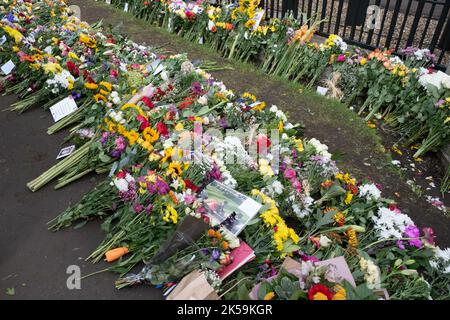 Blumen vor den Toren von Windsor Castle zu Ehren von Königin Elizabeth II. Nach ihrem Tod am 8. September 2022. Auf dem Vorderfoto der Royals in einem Wagen Stockfoto