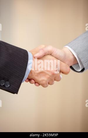 Wir sind uns einig. Nahaufnahme von zwei Geschäftsleuten, die die Hände schütteln. Stockfoto