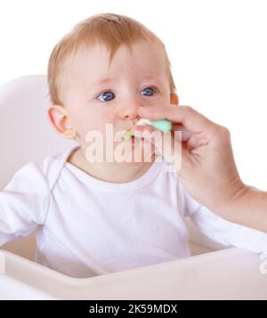 Essen das Essen, das Mama zur Verfügung stellt. Ein niedliches Baby, das von seiner Mutter einen Löffel voll Essen gefüttert wurde. Stockfoto