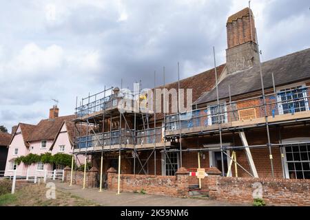 Gerüste um ein großes ummauertes Haus, das in einer Straße in Kersey, England, umgebaut und restauriert wird Stockfoto