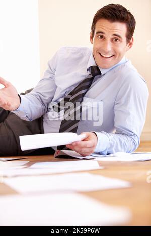 Papierkram - Sie haben gerade durch sie zu bekommen. Lächelnder junger Geschäftsmann, der seine Papiere mit positiver Einstellung erledigt. Stockfoto