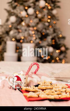 Weihnachtskekse mit Weihnachtsschmuck auf dem Bett im Innenraum Stockfoto