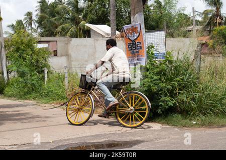 Ein Sri-lankischer Mann fährt nach der Arbeit mit dem Fahrrad nach Hause Stockfoto