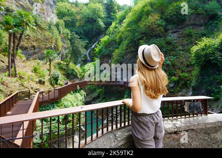 Mädchen, die auf dem Pfad die Landschaft mit Wasserfällen und den Schluchten eines natürlichen Canyons genießen Stockfoto