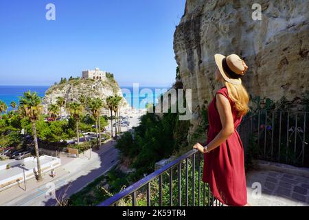 Urlaub in Tropea. Rückansicht der schönen Mode Mädchen genießen Blick auf das Kloster von Santa Maria dell'Isola von Tropea. Urlaub Italy im Sommer. Stockfoto