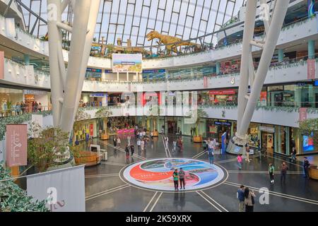 Blick auf das Innenatrium mit Stahlträgern des Norman Foster-Designs des zeltartigen Khan Shatyr Shopping Malls. Ein TREX im Hintergrund. In Astana, Stockfoto