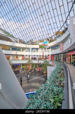 Blick auf das Innenatrium mit Stahlträgern des Norman Foster-Designs des zeltartigen Khan Shatyr Shopping Malls. Ein TREX im Hintergrund. In Astana, Stockfoto