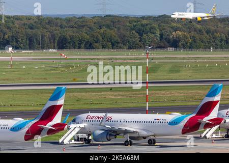 Flughafen Düsseldorf - Eurowings-Flugzeug in Parkposition während des Pilotenstreiks, Condor-Passagierflugzeug auf Landeanflug Stockfoto