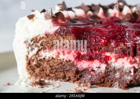 Schwarzes Waldgateaux Dessert, zum Teil gegessen, auf einem grauen Steinzeugteller Stockfoto