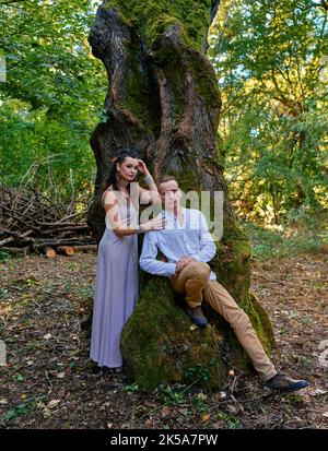 Mädchen mit einem Kerl geht in einem geheimnisvollen Wald Stockfoto