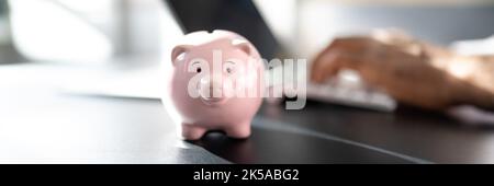 Sparen Sie Geld Online Mit Bank Piggy Und Laptop-Computer Stockfoto