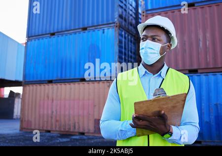 Logistik, Schifffahrt und Geschäftsmann in Covid mit Zwischenablage in Frachtcontainer Werft. Bauarbeiter mit Maske, die Lagerkontrollen für durchführen Stockfoto
